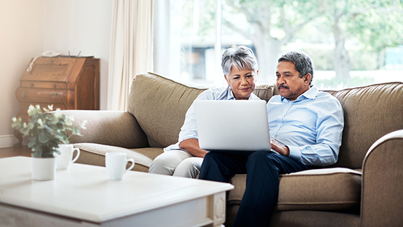couple-on-couch-looking-at-laptop-screen-understanding-neurogenic-bladder-disorder